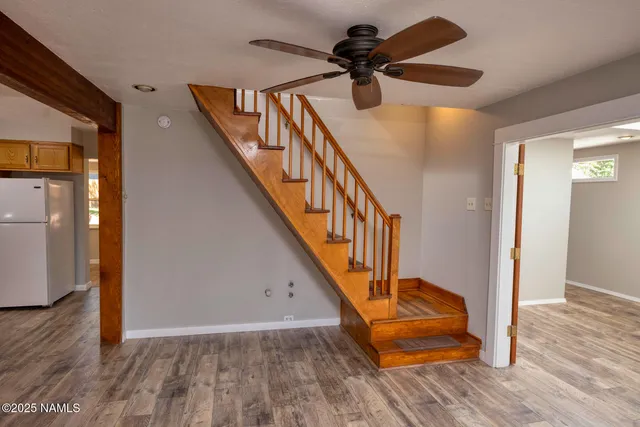 a view of a hallway with wooden floor and staircase