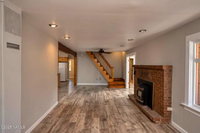 a view of a livingroom with wooden floor and a fireplace