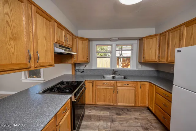 a kitchen with a sink stove top oven and cabinets