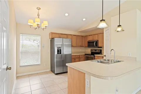 a kitchen with kitchen island a sink appliances and a counter top space