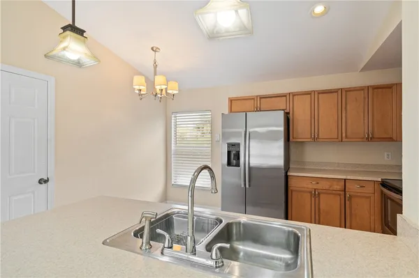 a kitchen with a refrigerator a microwave a sink and a counter top space