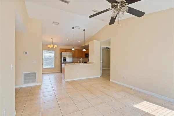 a view of an empty room and kitchen view
