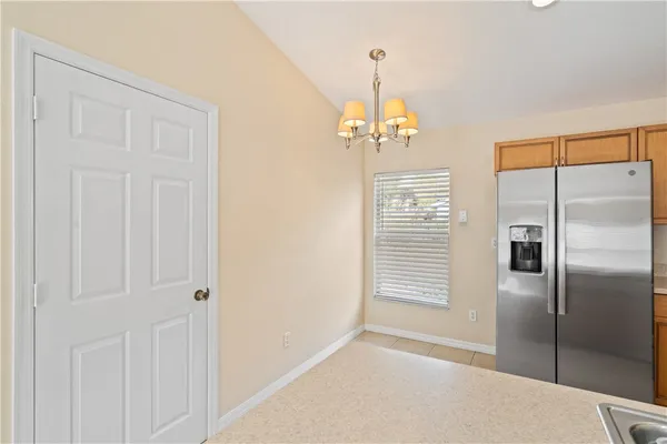 a kitchen with stainless steel appliances granite countertop a sink refrigerator a center island a stove and a window