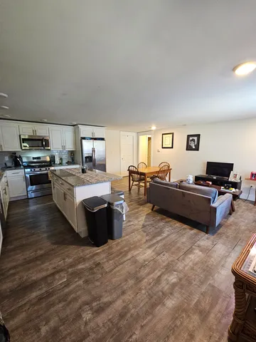 a living room with furniture kitchen view and a window