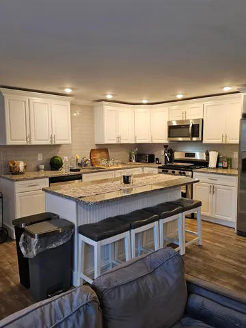 a kitchen with stainless steel appliances granite countertop a stove a sink and a microwave