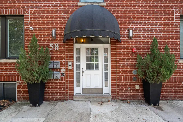 a front view of a house with a tree