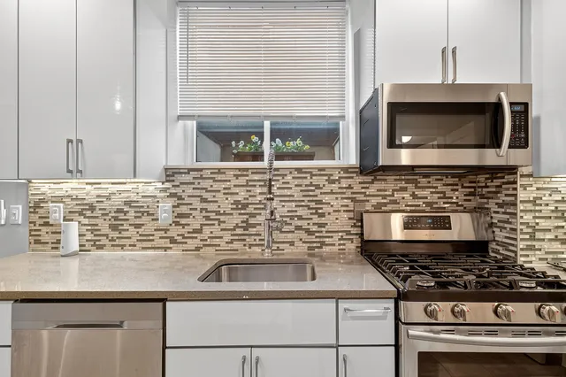 a kitchen with stainless steel appliances a stove and a microwave