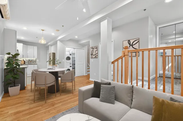 a living room with furniture kitchen view and a large window