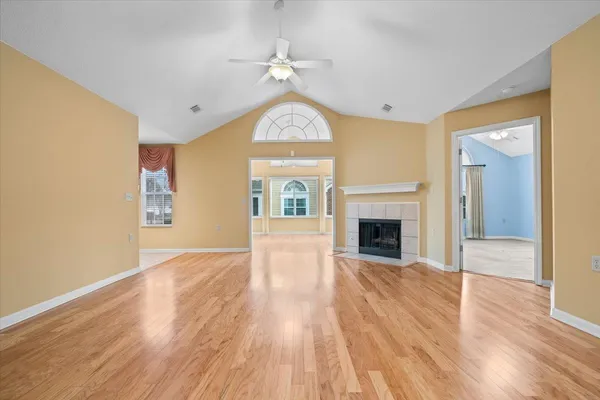 a view of an empty room with a fireplace and a window