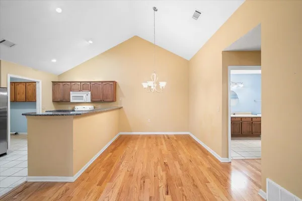 a kitchen with stainless steel appliances granite countertop a refrigerator a stove and a sink