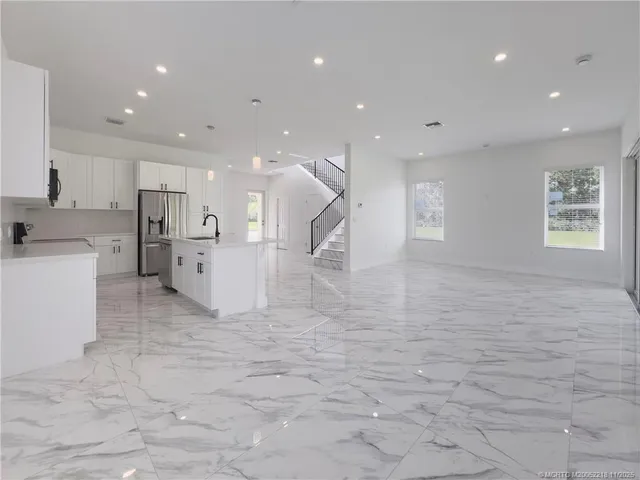 a big room with white cabinets and kitchen view