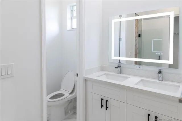 a bathroom with a sink a toilet and mirror