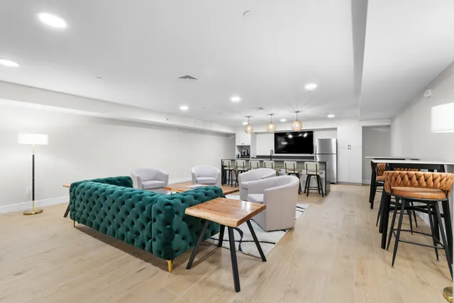 a living room with furniture a flat screen tv and kitchen view