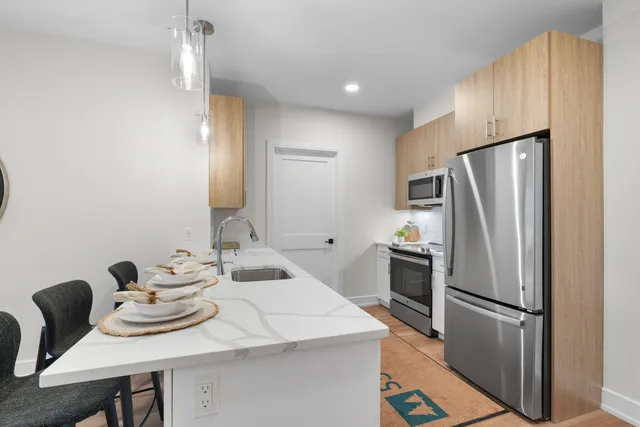 a kitchen with a refrigerator a stove a sink and a dining table