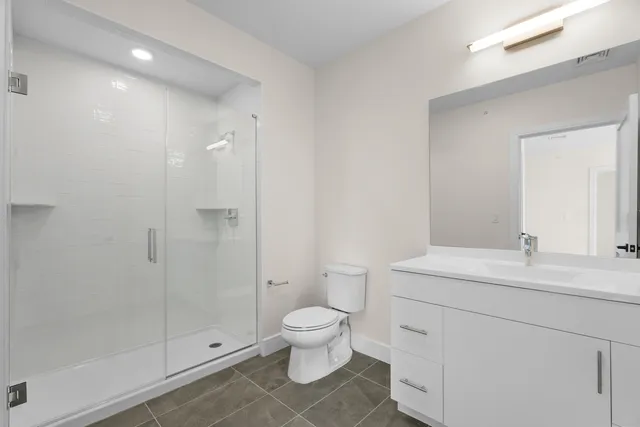 a bathroom with a sink a toilet and shower