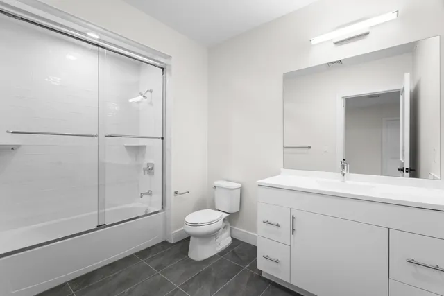 a spacious bathroom with a double vanity sink toilet and shower
