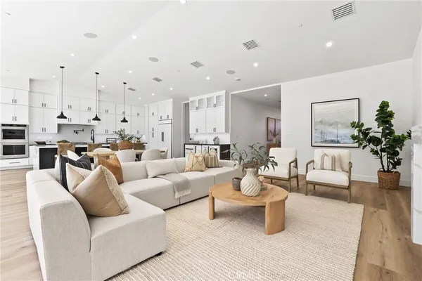 a large room with stainless steel appliances kitchen island lots of white furniture