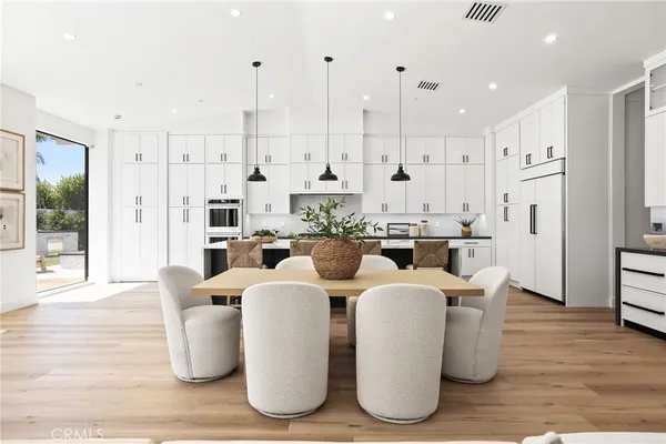 a large kitchen with stainless steel appliances kitchen island granite countertop a large center island a stove a cabinets and a dining table