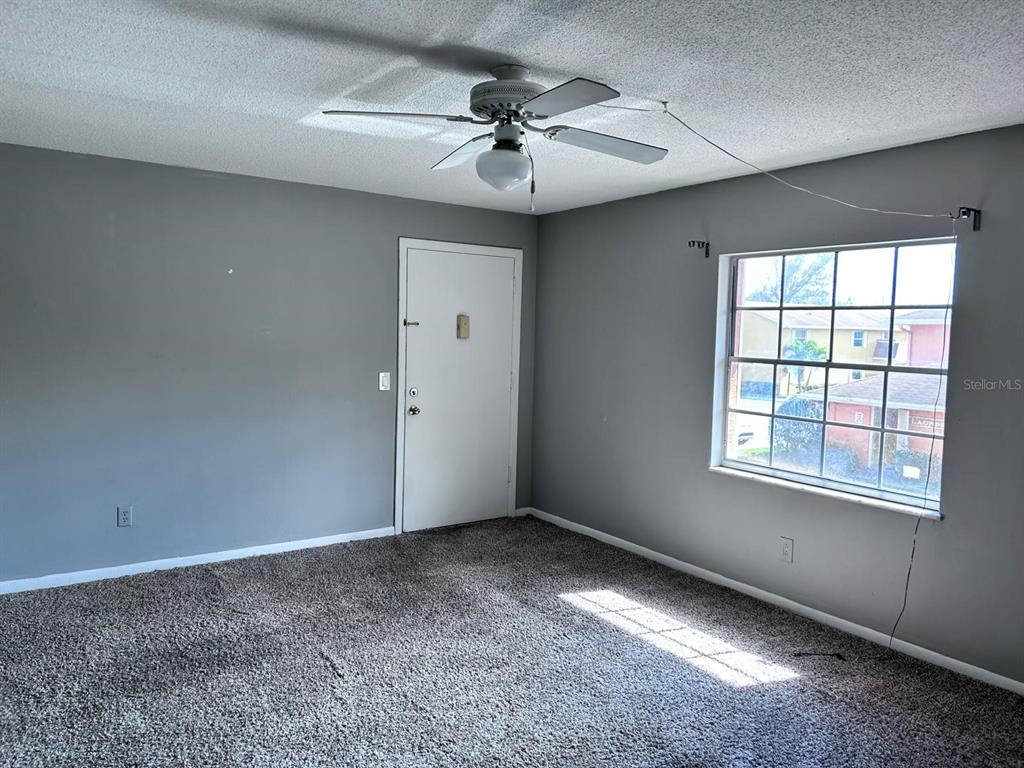 1625 West Oak Ridge Road, Unit C Orlando, FL 32809 - Photo 4 of 11 an empty room with a ceiling fan and window