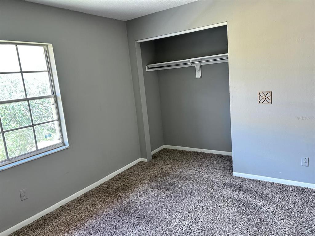 1625 West Oak Ridge Road, Unit C Orlando, FL 32809 - Photo 9 of 11 an empty room with windows and closet