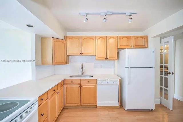 a kitchen with a refrigerator sink and cabinets