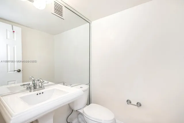 a bathroom with a sink a toilet and mirror