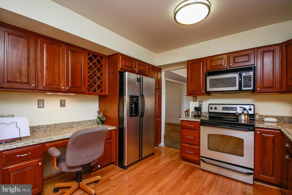 2667 Sandymount Road Finksburg, MD 21048 - Photo 14 of 30 a kitchen with granite countertop wooden cabinets stainless steel appliances and a wooden floor