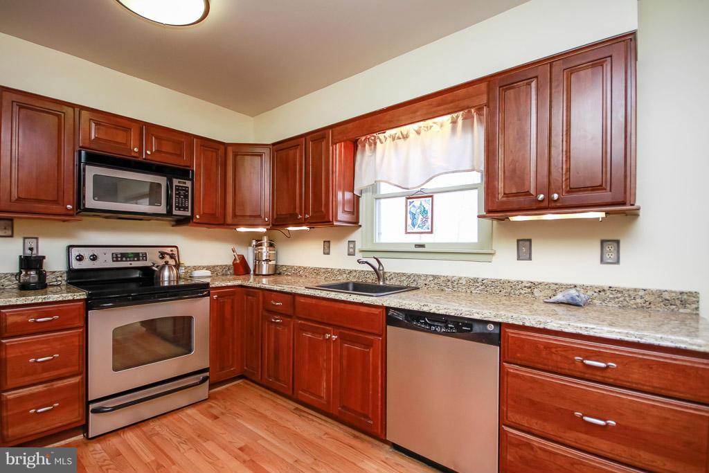 2667 Sandymount Road Finksburg, MD 21048 - Photo 15 of 30 a kitchen with granite countertop wooden cabinets stainless steel appliances a sink and a window