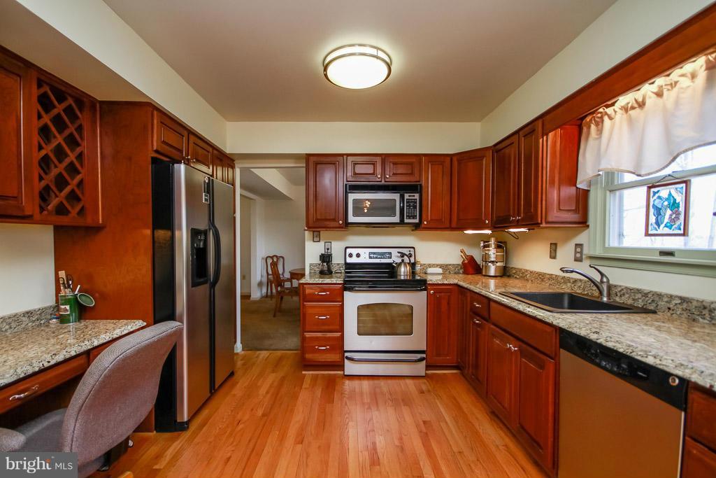 2667 Sandymount Road Finksburg, MD 21048 - Photo 16 of 30 a kitchen with granite countertop wooden floors stainless steel appliances a sink and a window