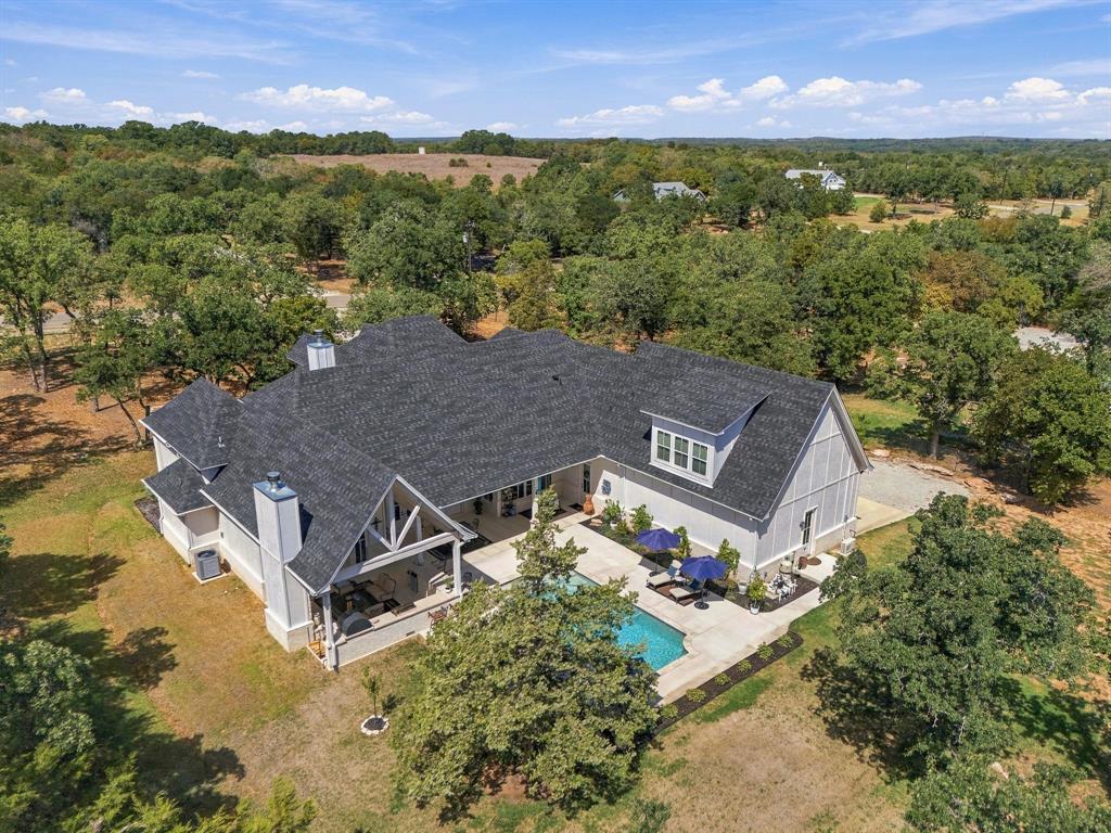 330 Rolling Bnd Road Alvord, TX 76225 - Photo 3 of 36 Expansive property featuring a dark grey shingle roof, light-colored siding, and multiple gables