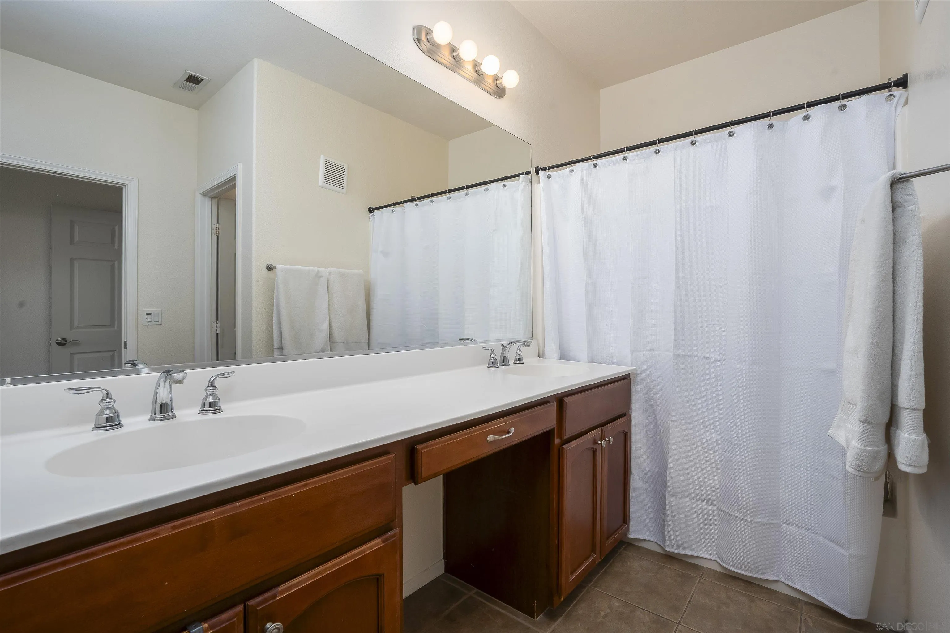 289 Reef Point Way, Unit 3 Oceanside, CA 92058 - Photo 12 of 23 a bathroom with a double vanity sink and a mirror