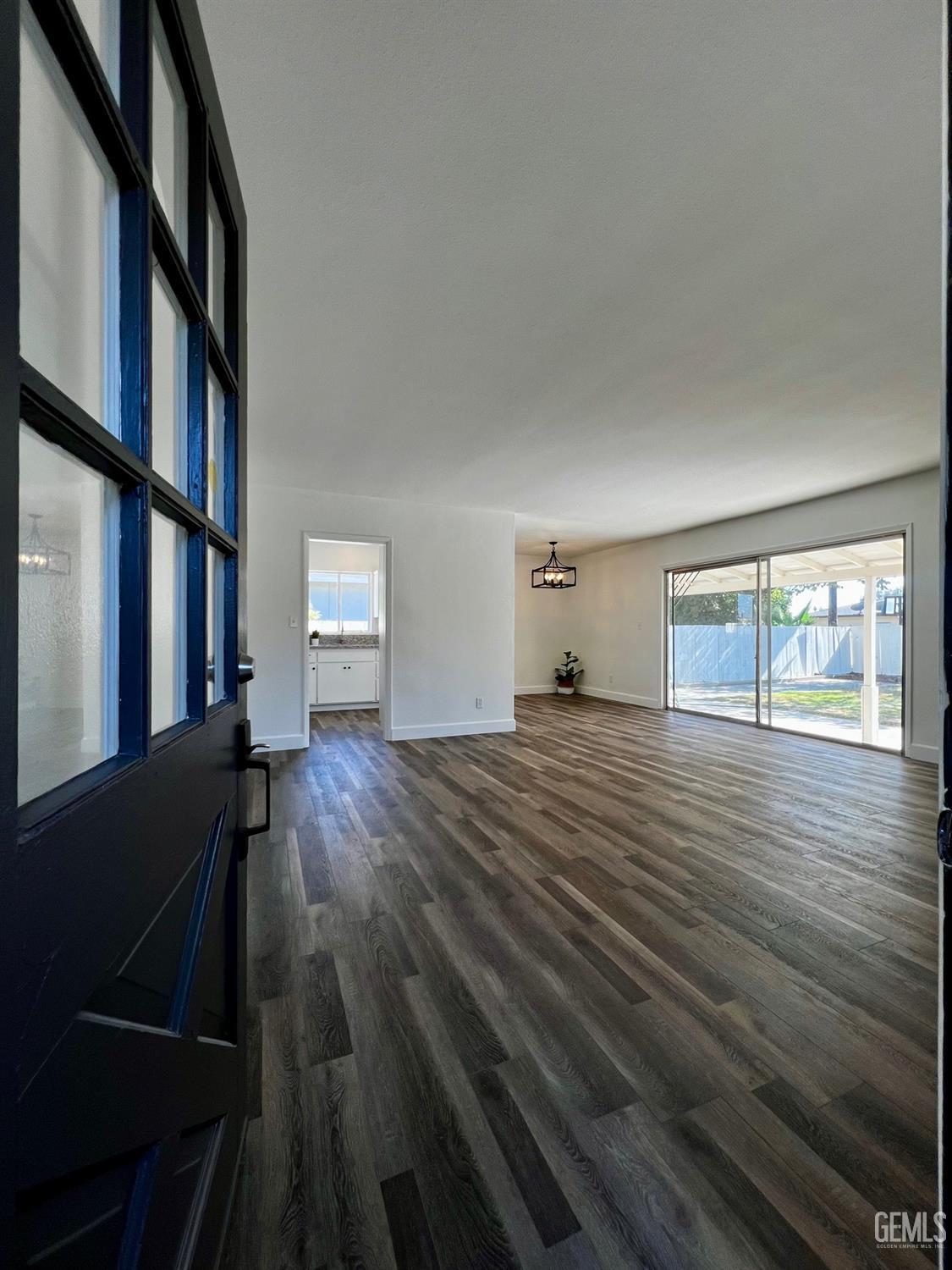 Undisclosed Address Bakersfield, CA 93304 - Photo 3 of 20 a view of empty room with wooden floor and fan