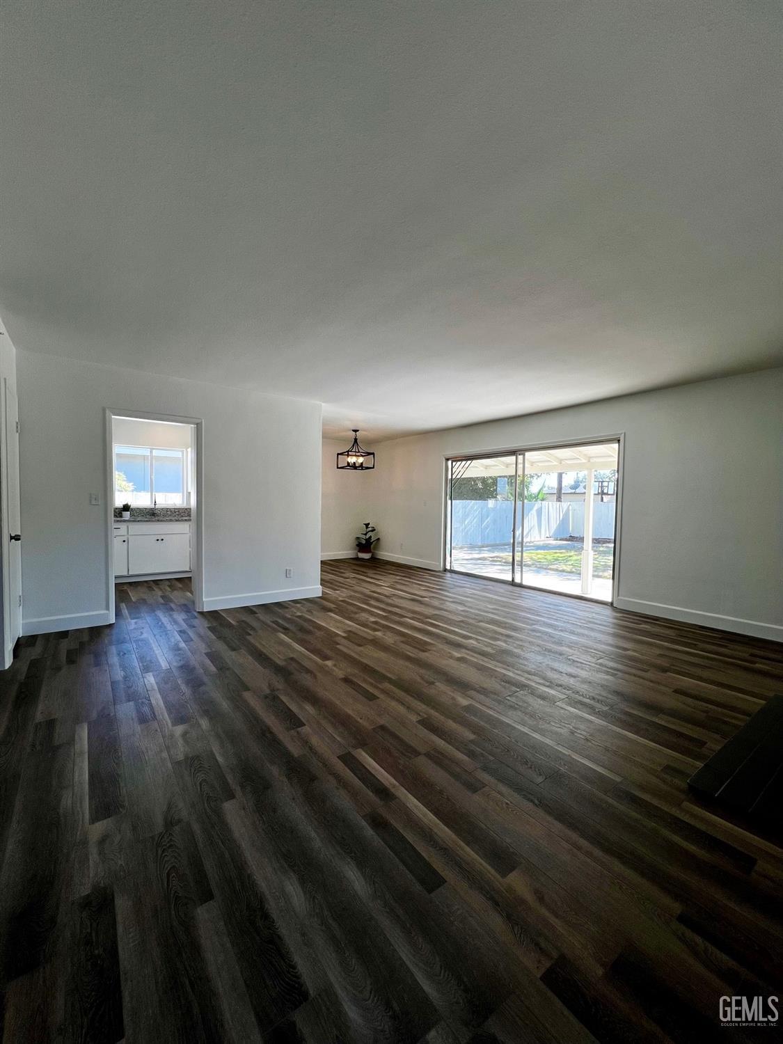 Undisclosed Address Bakersfield, CA 93304 - Photo 4 of 20 a view of empty room with wooden floor and fan