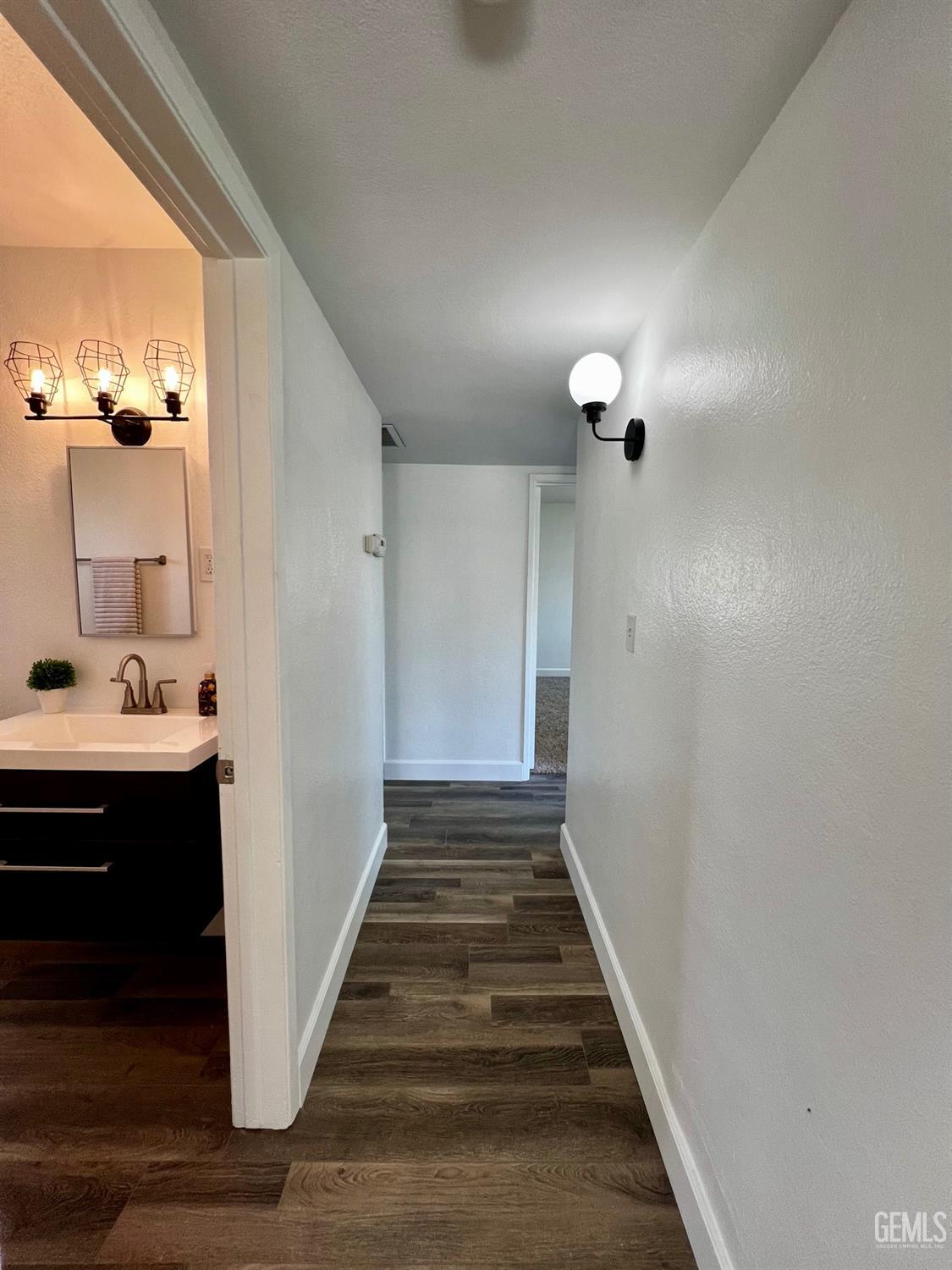 Undisclosed Address Bakersfield, CA 93304 - Photo 10 of 20 a view of a hallway with a sink and a mirror