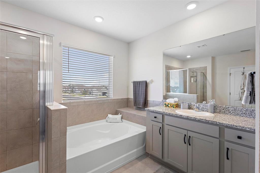 8953 Southwest 50th Terrace Ocala, FL 34476 - Photo 32 of 49 a bathroom with a sink double vanity granite tub shower and a mirror