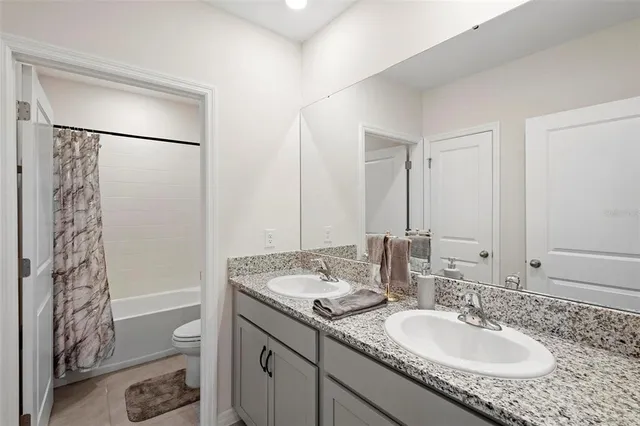 a bathroom with a granite countertop sink a shower and a mirror