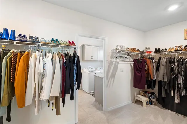 a view of walk in closet with clothes and shoes