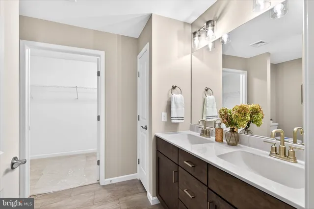 a bathroom with a double vanity sink mirror and shower