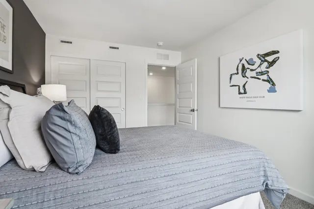 a bedroom with a bed and a large window