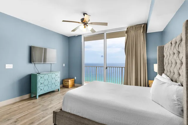 a bedroom with a bed chandelier and dresser