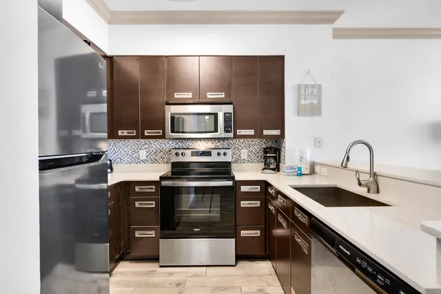 a kitchen with stainless steel appliances granite countertop a sink stove and refrigerator