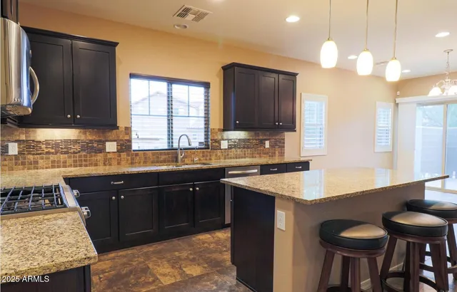 a kitchen with granite countertop a sink stove and cabinets