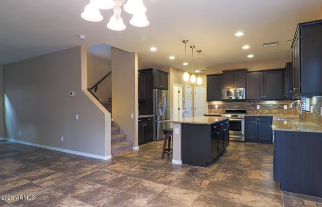 a kitchen with stainless steel appliances granite countertop a refrigerator and a stove