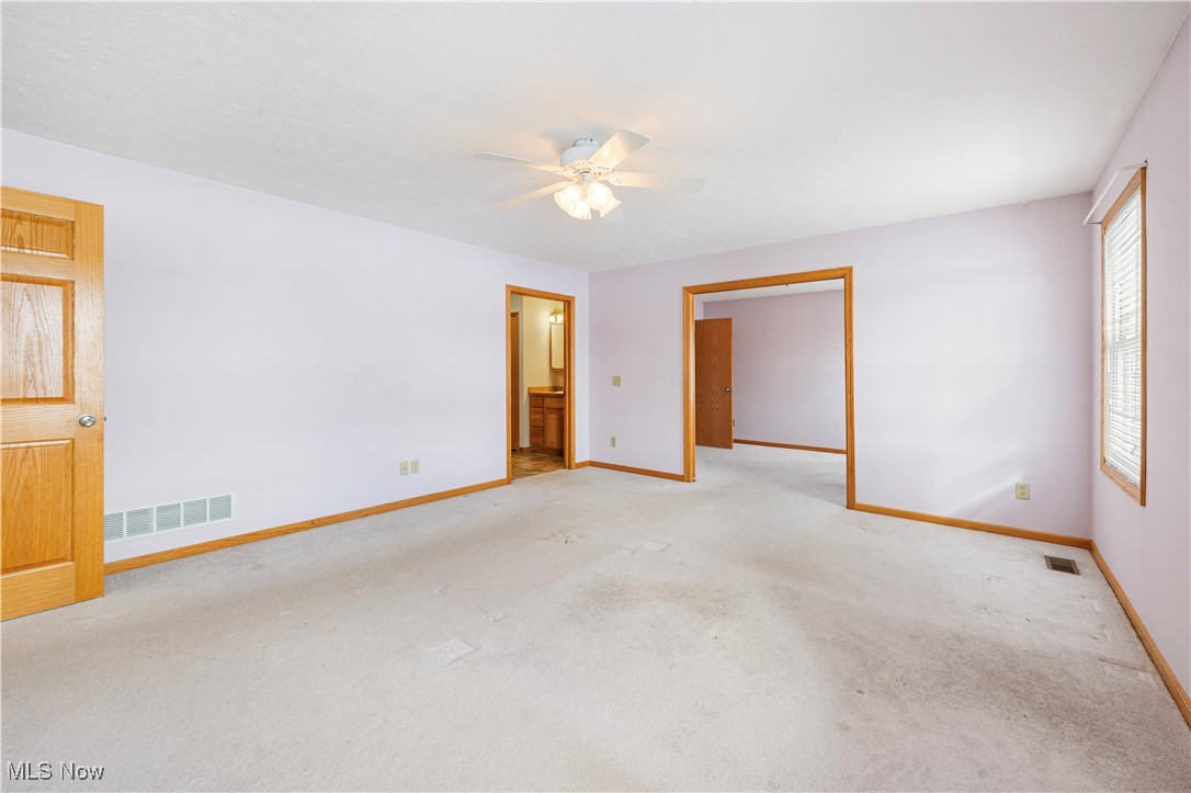 706 Watson Road Deerfield, OH 44411 - Photo 12 of 36 Primary bedroomCarpeted empty room featuring ceiling fan
