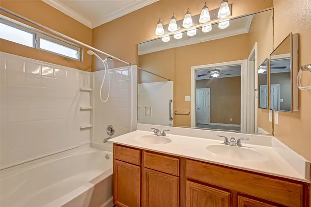 a bathroom with a sink double vanity granite tub shower and a mirror