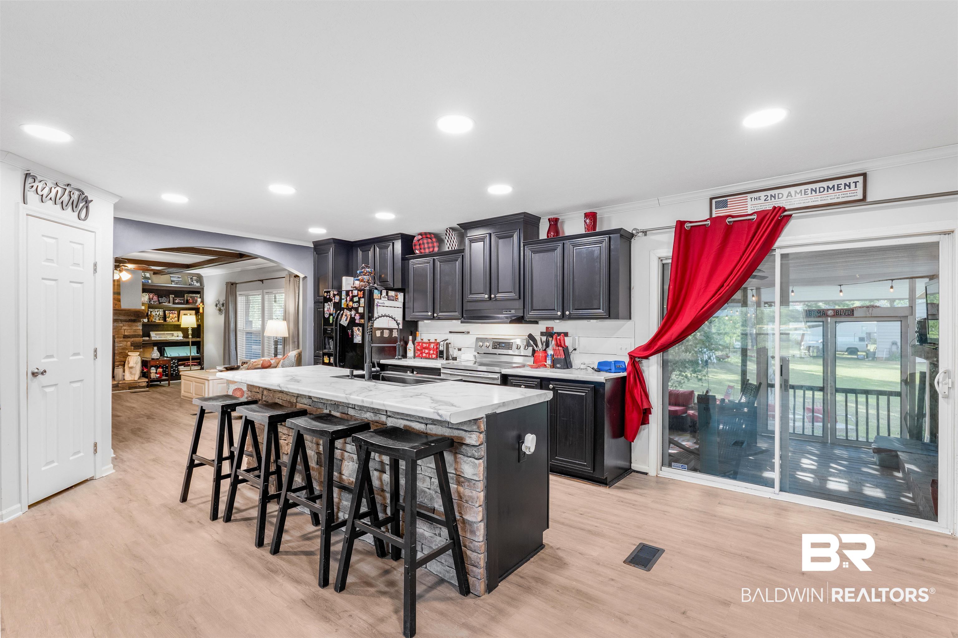 6921 Piney Woods Road Foley, AL 36535 - Photo 11 of 44 Kitchen featuring sink, light hardwood / wood-style flooring, a center island with sink, and a kitchen breakfast bar
