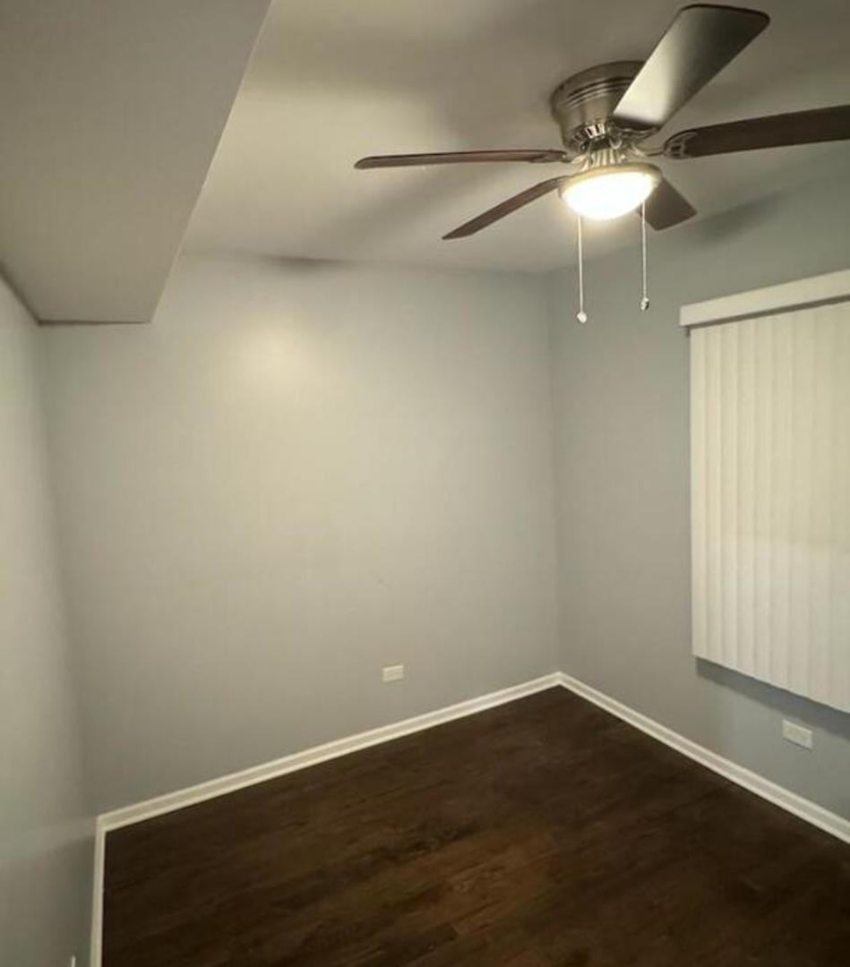 1836 South May Street, Unit 1 Chicago, IL 60608 - Photo 7 of 15 an empty room with wooden floor and fan