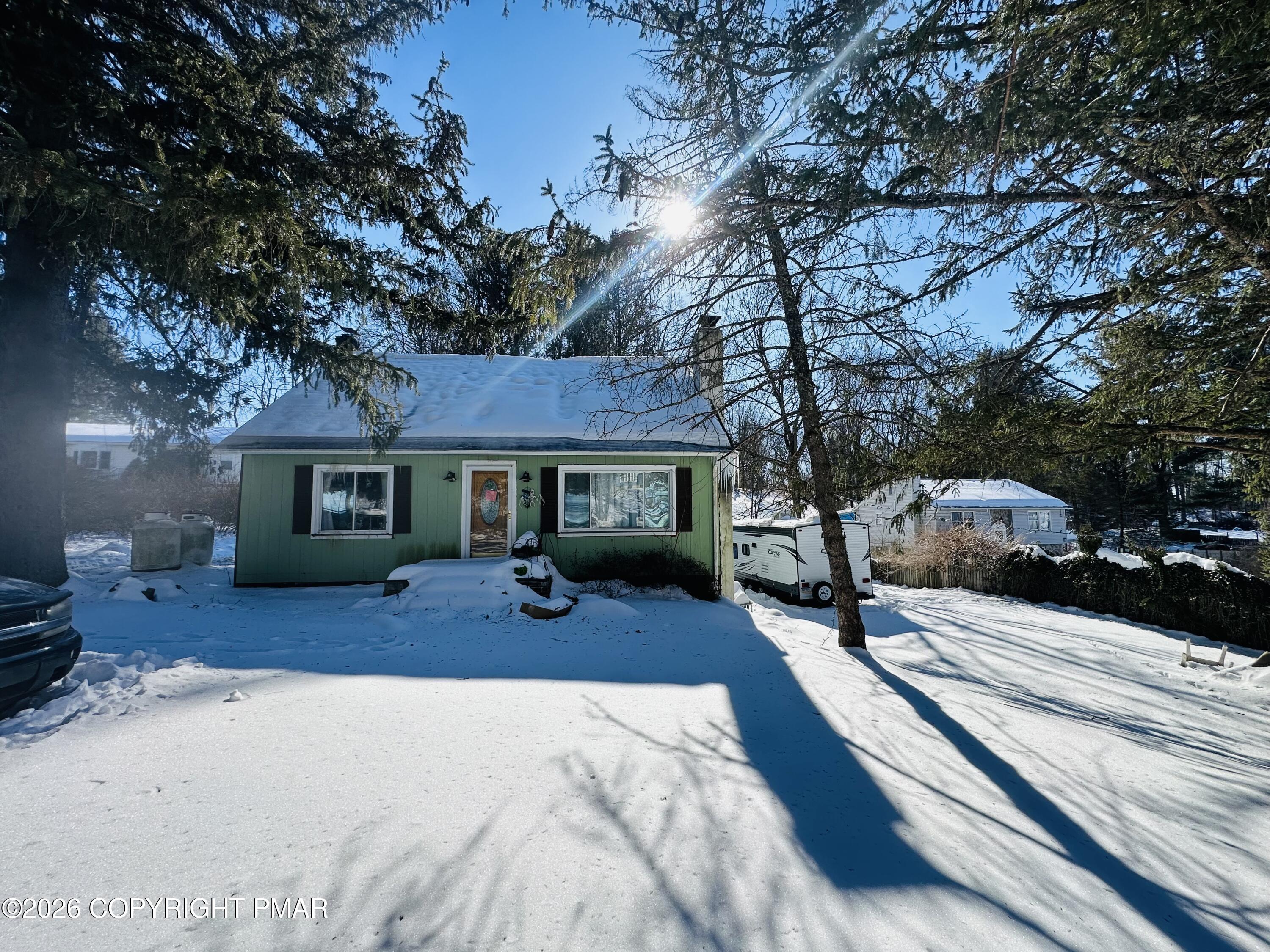a front view of a house with a yard outdoor seating and yard with car parked