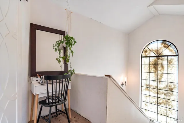 a view of a hallway with wooden floor and a potted plant