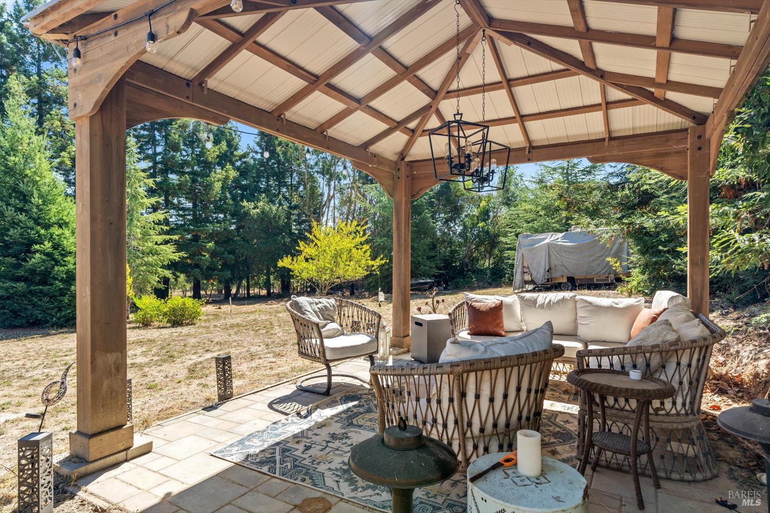 8061 Elphick Road Sebastopol, CA 95472 - Photo 22 of 40 a view of a patio with a dining table and chairs with wooden floor